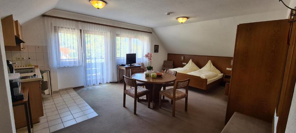 a kitchen and living room with a table and a couch at Pension Hauber - Kirchturmblick in Herrischried