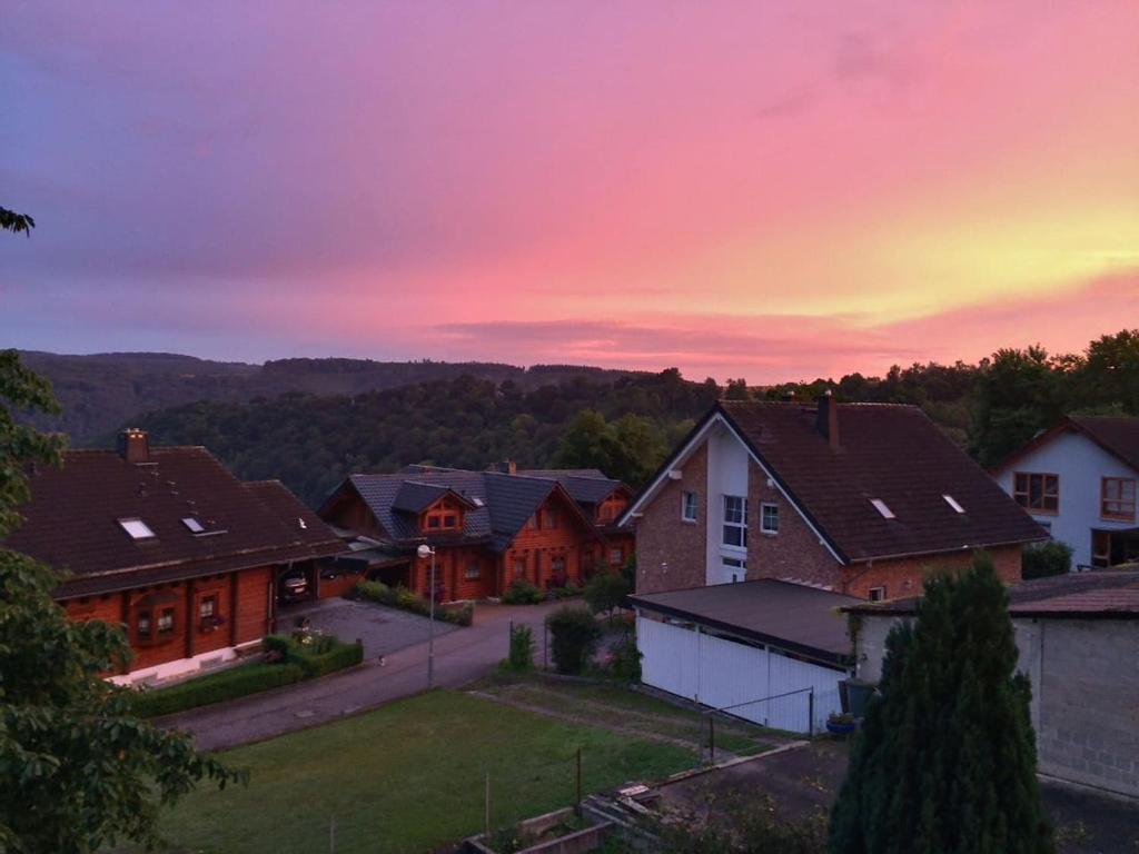 un grupo de casas con una puesta de sol en el fondo en Heidrun's Home, en Altendiez