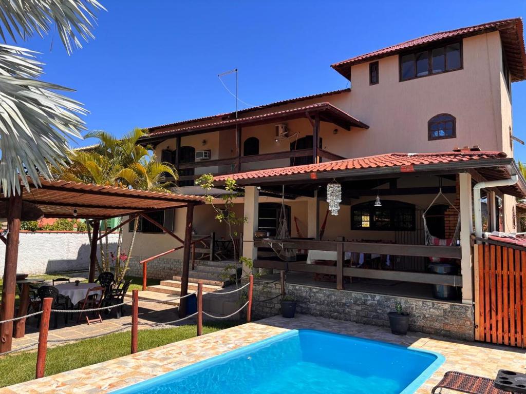 a house with a swimming pool in front of a house at Casa Barra Mar in Saquarema