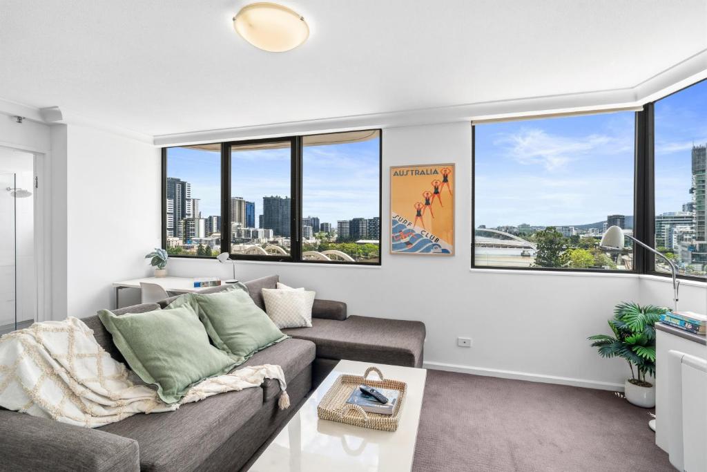a living room with a couch and large windows at Riverview Sanctuary - Walk to CBD & South Bank in Brisbane