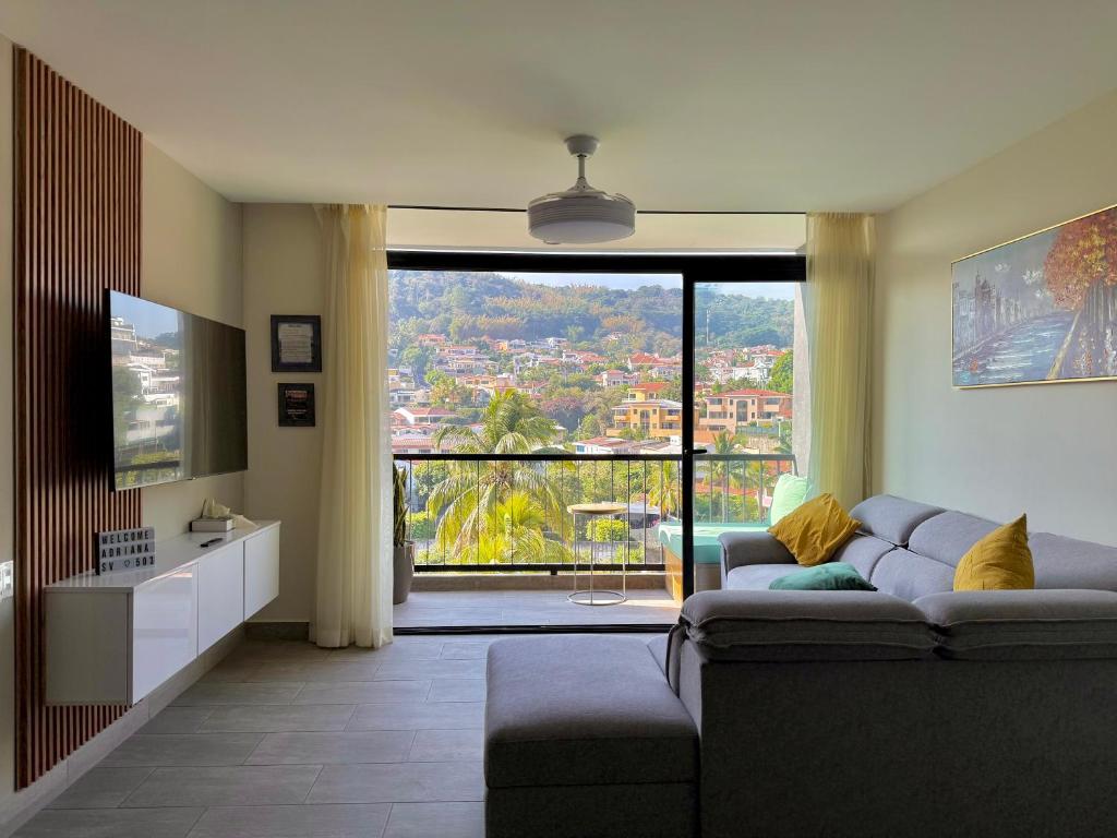 a living room with a couch and a large window at Avitat Link in San Salvador
