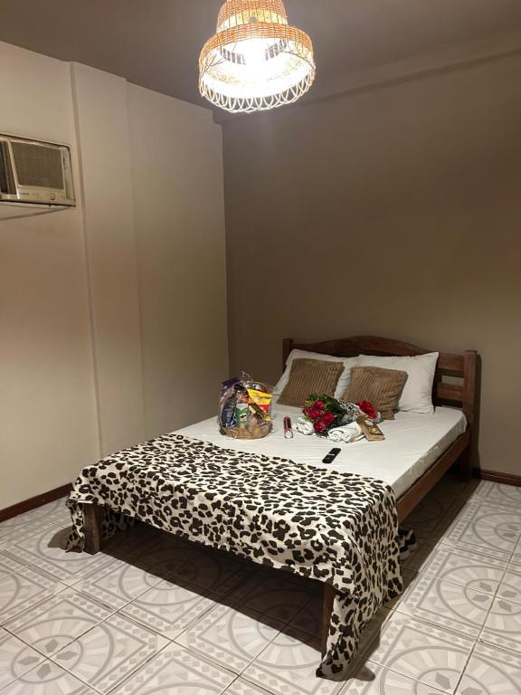 a bedroom with a leopard print bed with a chandelier at Suítes estrela dalva in Lauro de Freitas