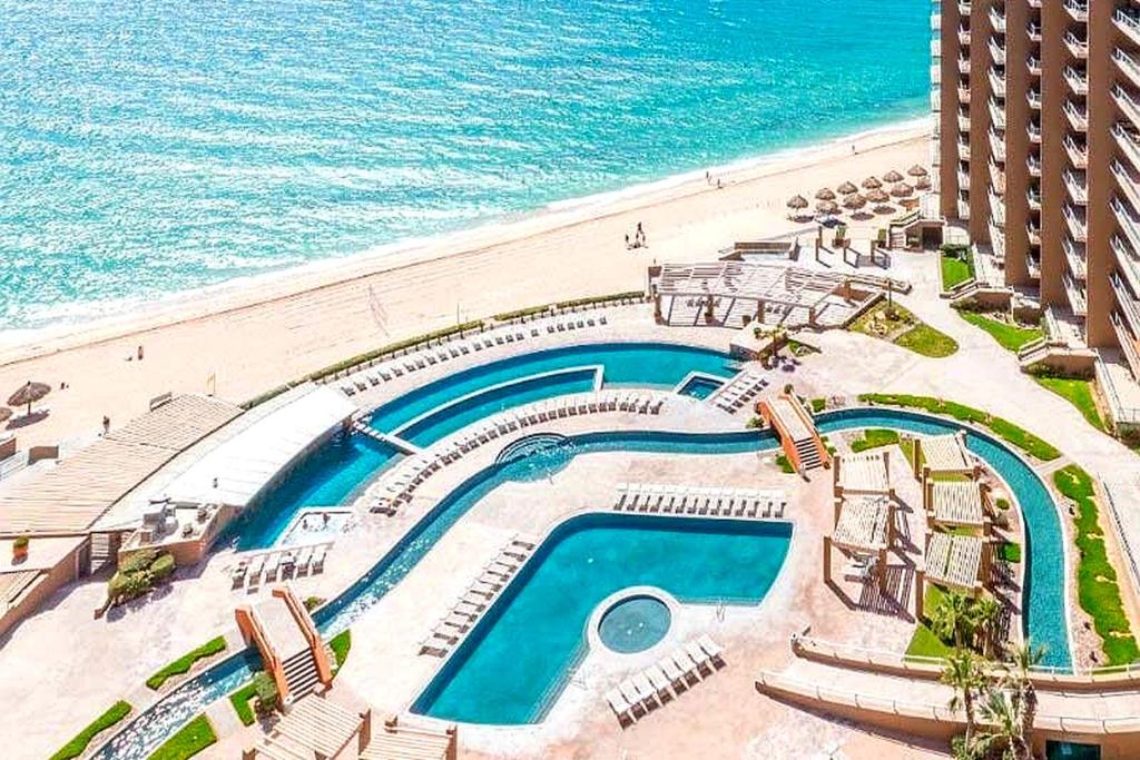 an aerial view of a swimming pool next to a beach at Las Palomas F-1402 Oceanfront Premium Condo - Sleeps 4 in Puerto Peñasco
