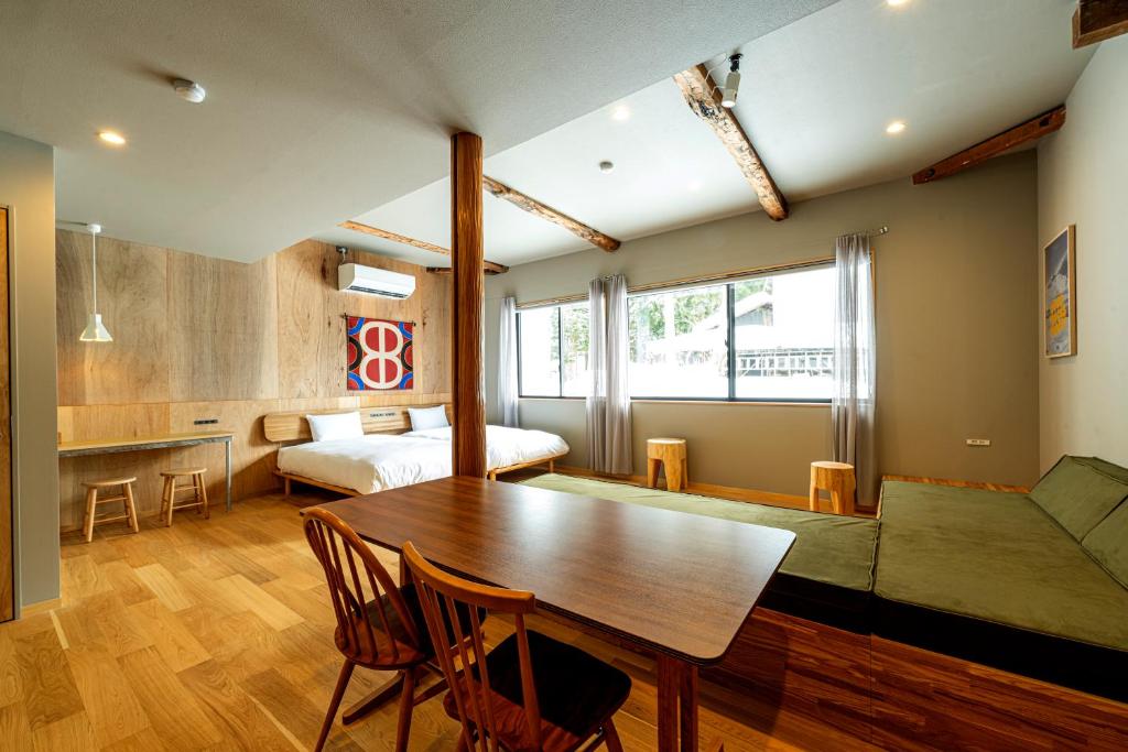 a living room with a table and a bed at B and D HAKUBA IWATAKE in Hakuba