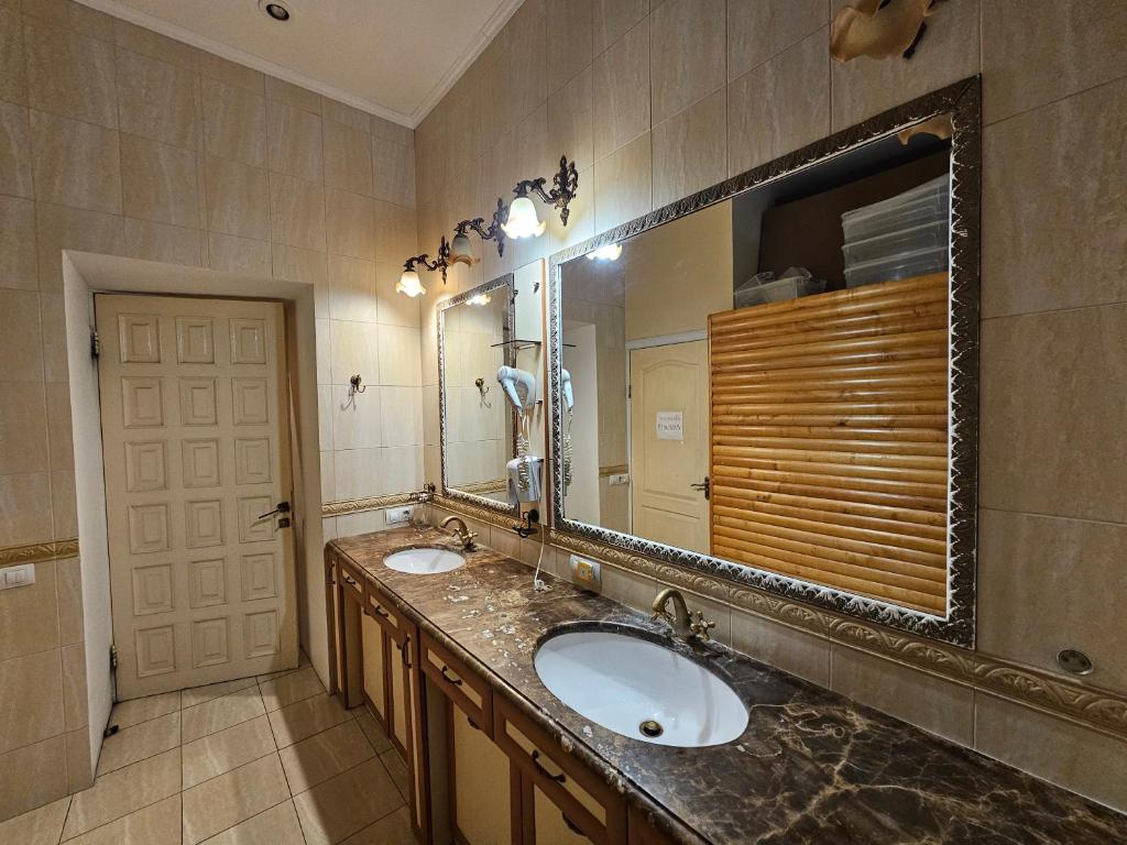 a bathroom with two sinks and a large mirror at Хостел Палац Спорта in Kyiv
