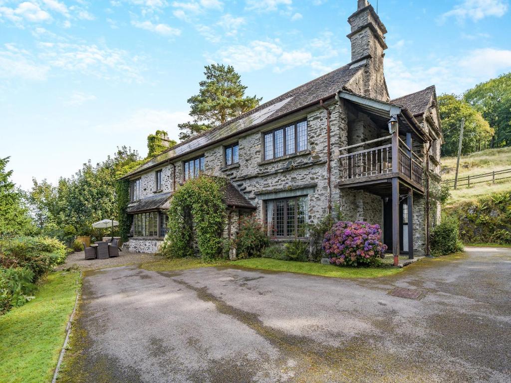 an old stone house with a porch and a balcony at High Biggin in Windermere