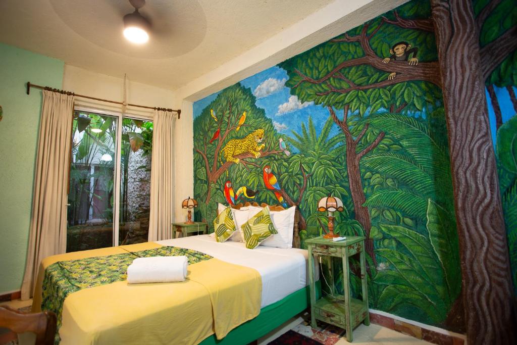 a bedroom with a painting on the wall at La Selva by Majikal B&B in Mérida