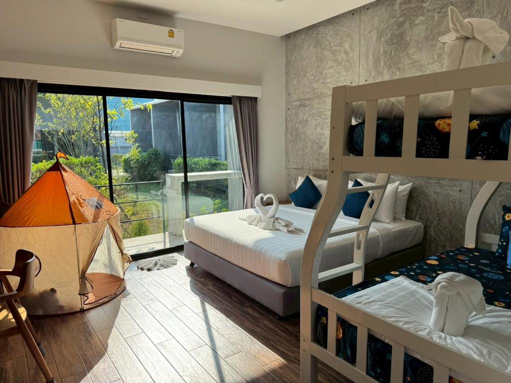 a bedroom with two bunk beds and a balcony at Destino Hotel Surin in Ban Khok Kachai