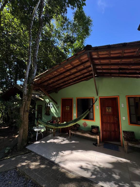 a house with a hammock in front of it at Apartamentos Ouro Verde in Angra dos Reis