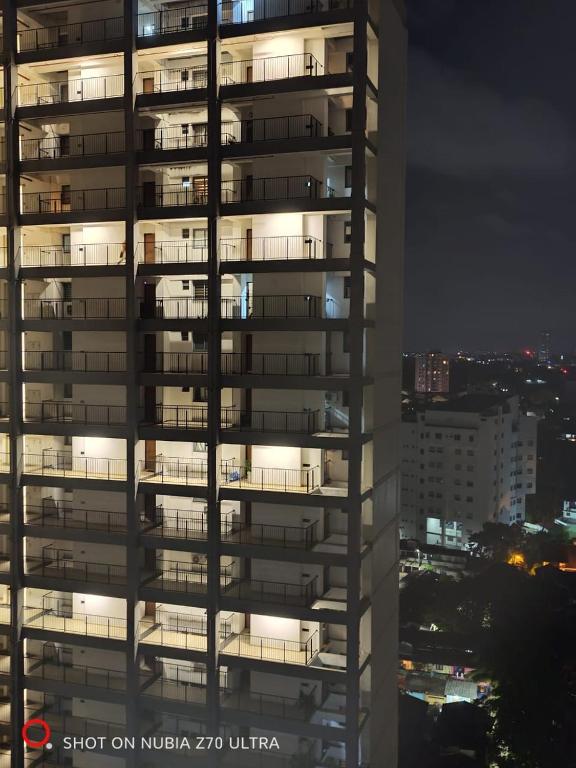 a night view of a tall building with lights on at Urban View by CityScape in Colombo