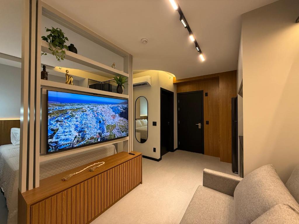 a living room with a large flat screen tv at Sky Designer Alphaville - 1611 in Barueri