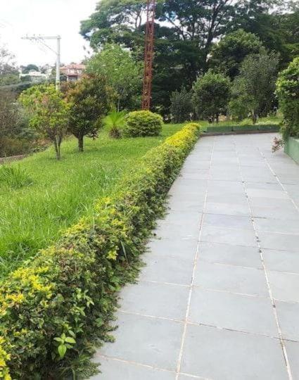 a walkway in a park with bushes and trees at Condomínio Vila Gustavo excelente localização in Caraguatatuba