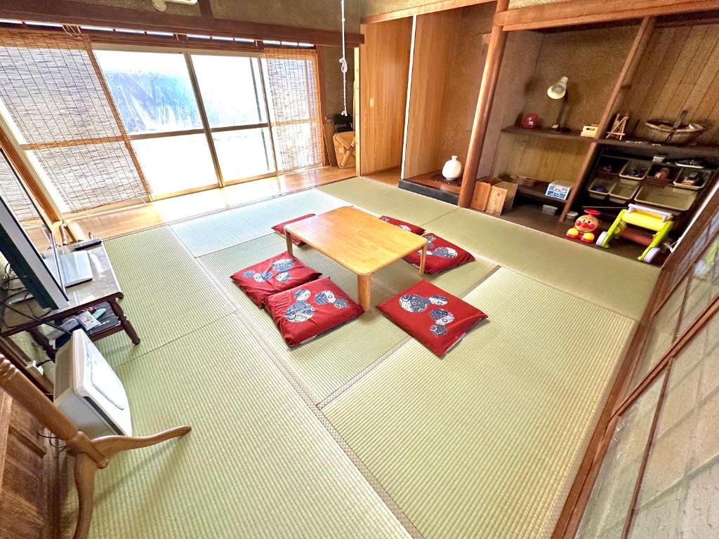 an overhead view of a living room with a table and red pillows at イトノ-itono- in Goto