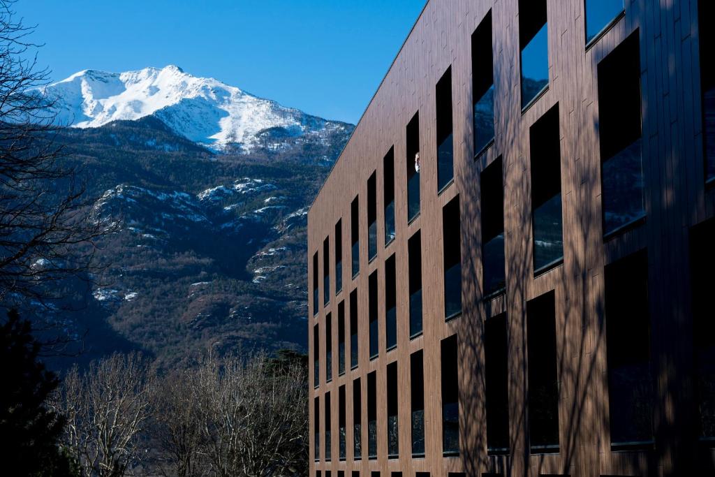 a building with a view of a snow covered mountain at Parc Hotel Billia in Saint Vincent