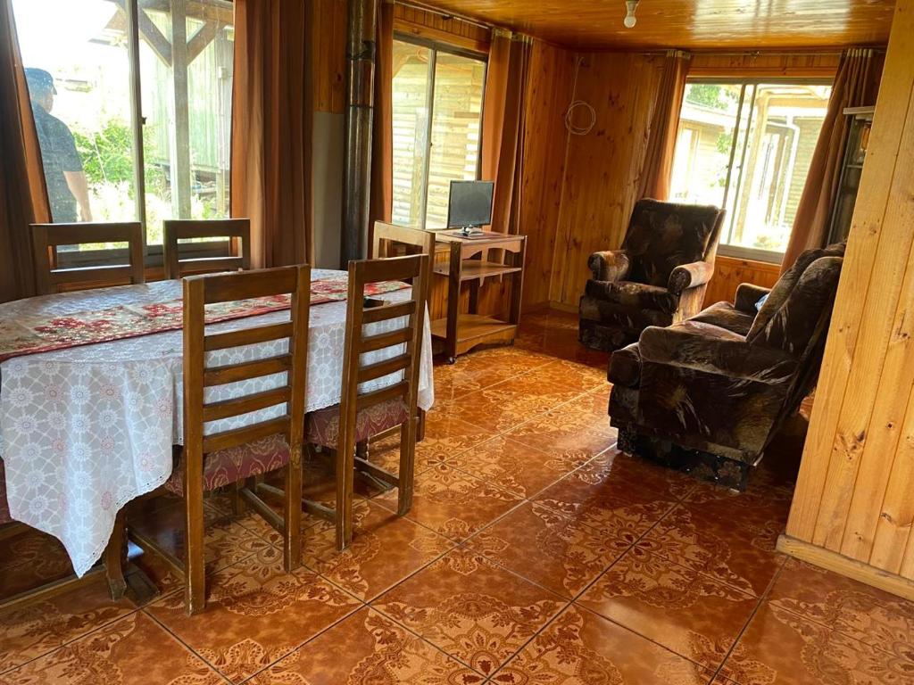 a living room with a table and chairs and a television at Cabaña Peuño in Chovellén