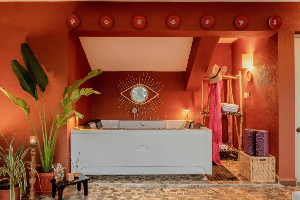 a living room with orange walls and a white tub at Casa Superfly 2BHK with Rooftop Jacuzzi & Terrace Deck Excellent Location Boilermaker Thalassa in Oxel