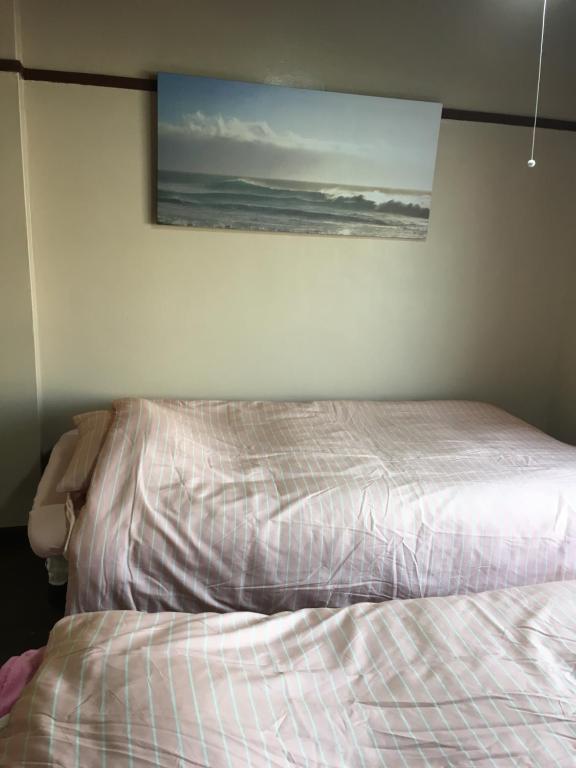a bed in a bedroom with a picture on the wall at 山下ビル403 in Kitakyushu