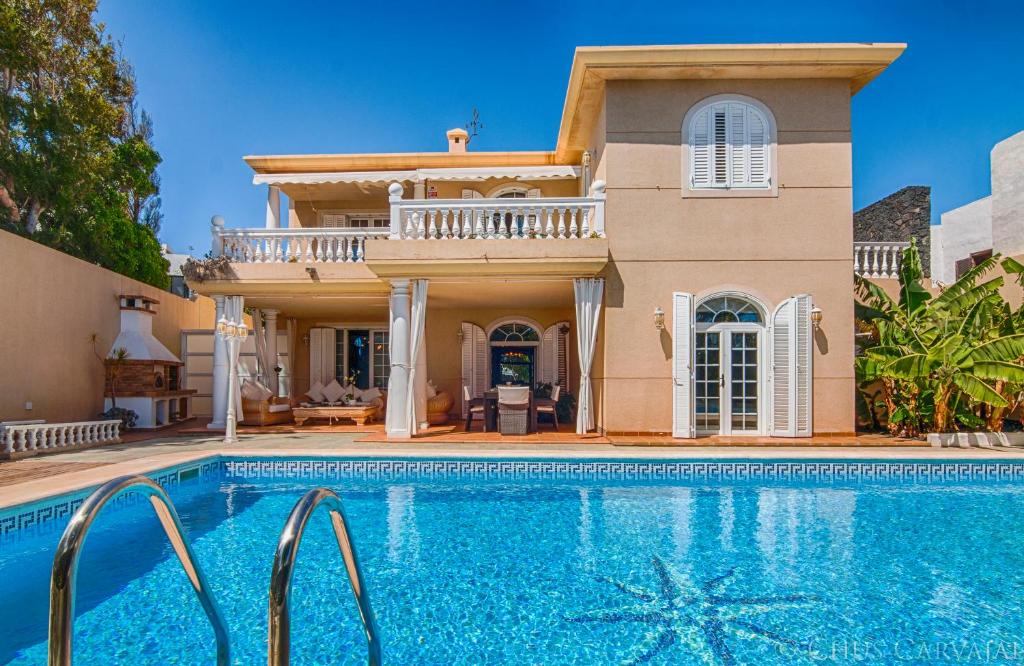 a villa with a swimming pool in front of a house at Villa La Concha Beachfront Heated Pool in Playa Honda