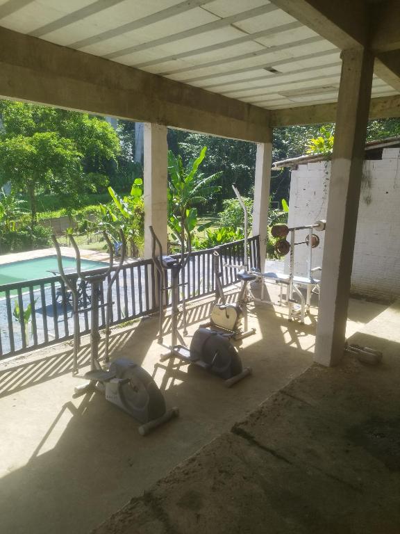 two exercise bikes on a porch next to a pool at chácara Cantagalo in Caraguatatuba