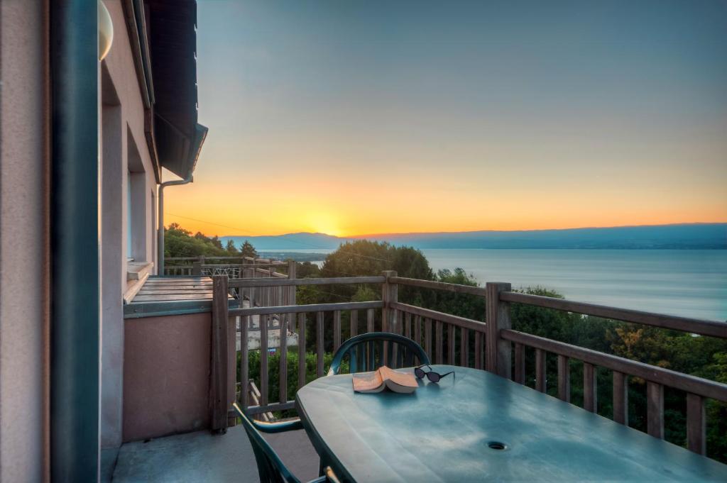 una mesa en un balcón con vistas al océano en Zenitude Hôtel-Résidences Les Terrasses du Lac, en Évian-les-Bains