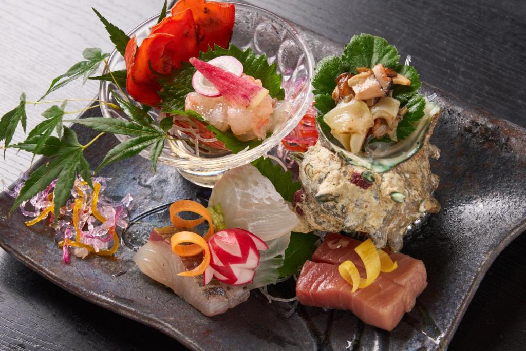 ein Teller mit Essen, Salat und Gemüse in der Unterkunft あじ彩の宿小浜荘 in Toba