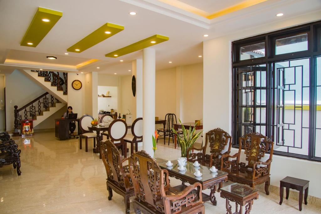 a living room with a table and chairs and a staircase at Mi Kha Homestay in Hoi An