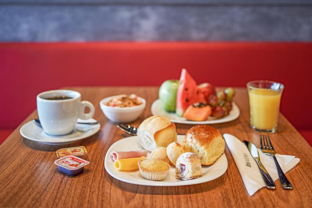 A breakfast spread offers coffee, juice, fruit, yogurt, breads, pastries, and spreads.