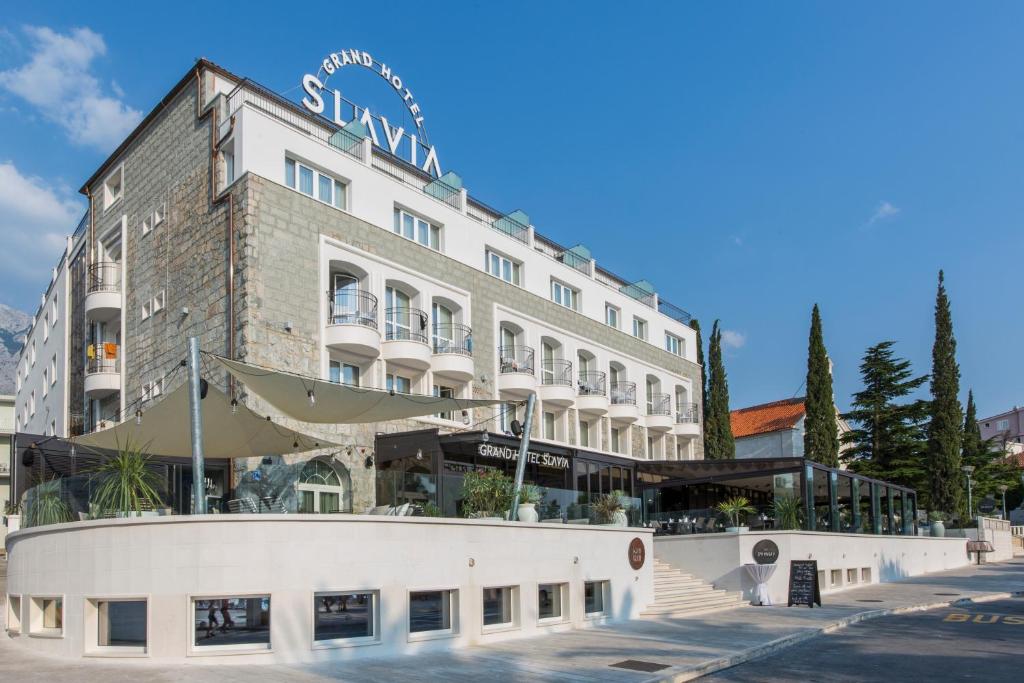 a large white building with a sign on it at Grand Hotel Slavia in Ba&scaron;ka Voda