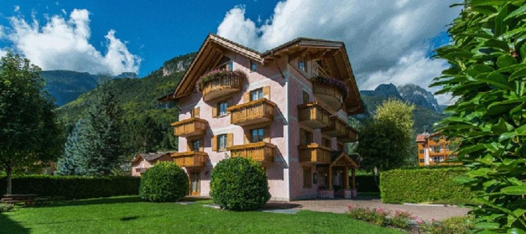 ein großes Haus inmitten eines Gartens in der Unterkunft Residence Rio Piccolo in Molveno