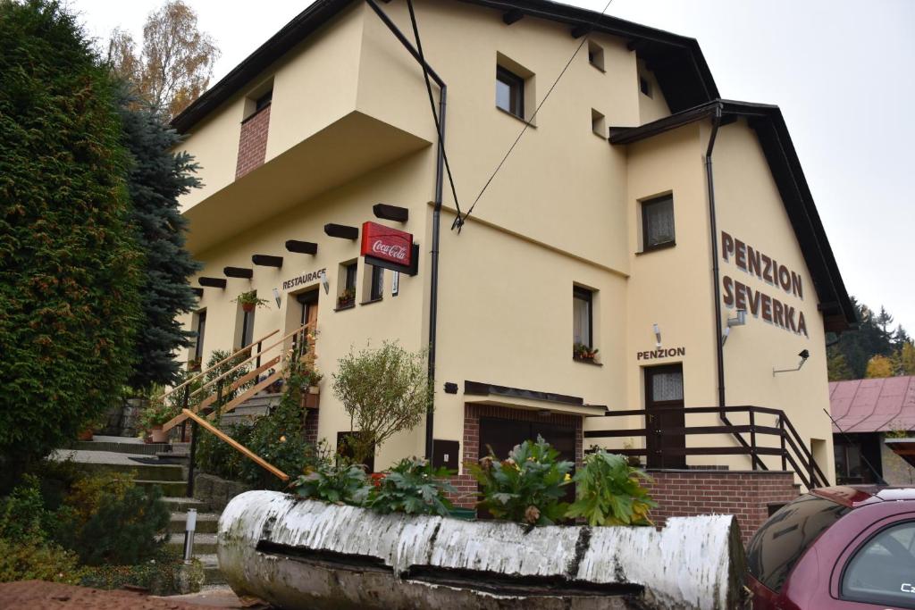 a building with a sign on the side of it at Penzion Severka in Smržovka