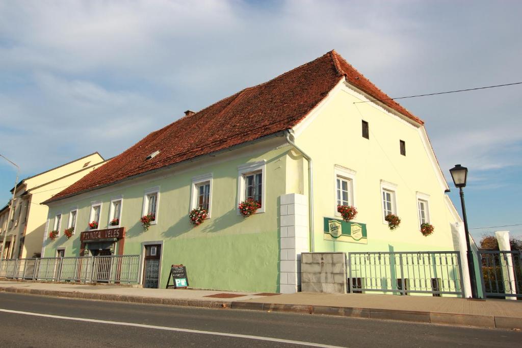 un edificio blanco y verde al lado de una calle en Guesthouse Veles en Slovenska Bistrica