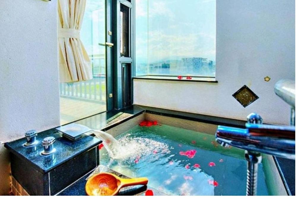 a pool of water with a fountain in a room at 建築師湧泉泡湯會館 in Dongshan