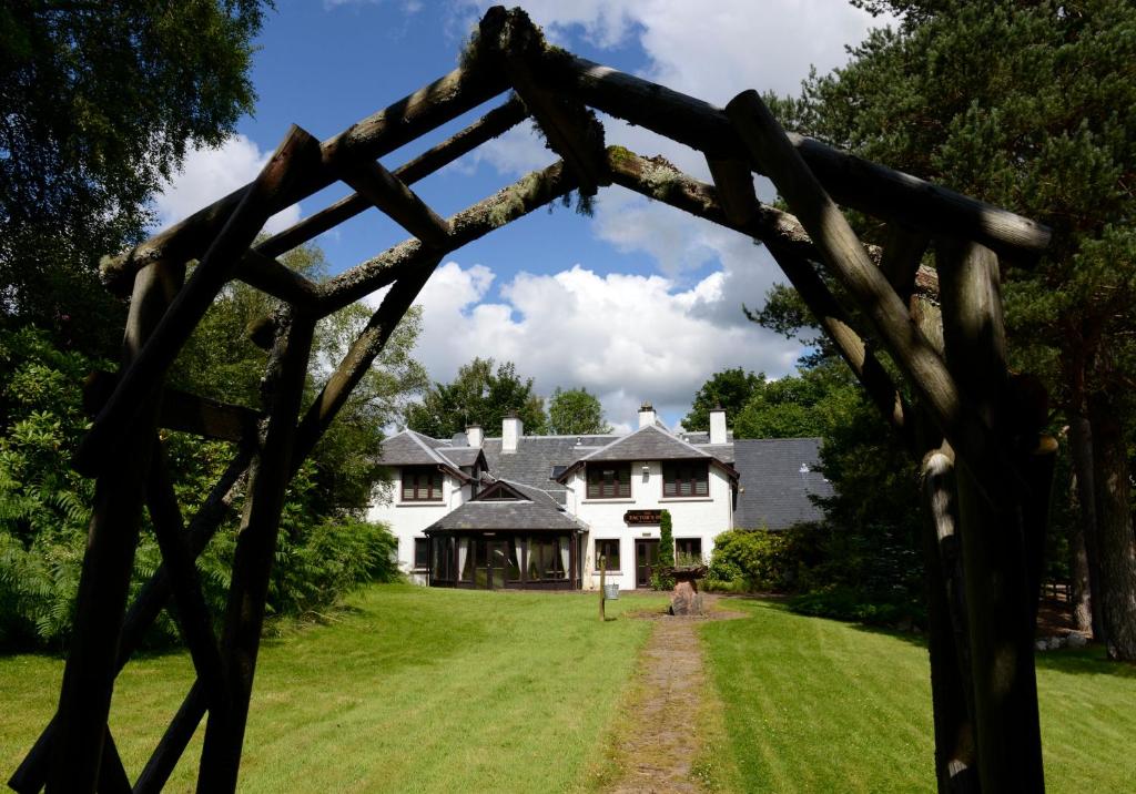 vistas a una casa a través de un arco de madera en The Factor's Inn & Factor's Cottage, en Fort William