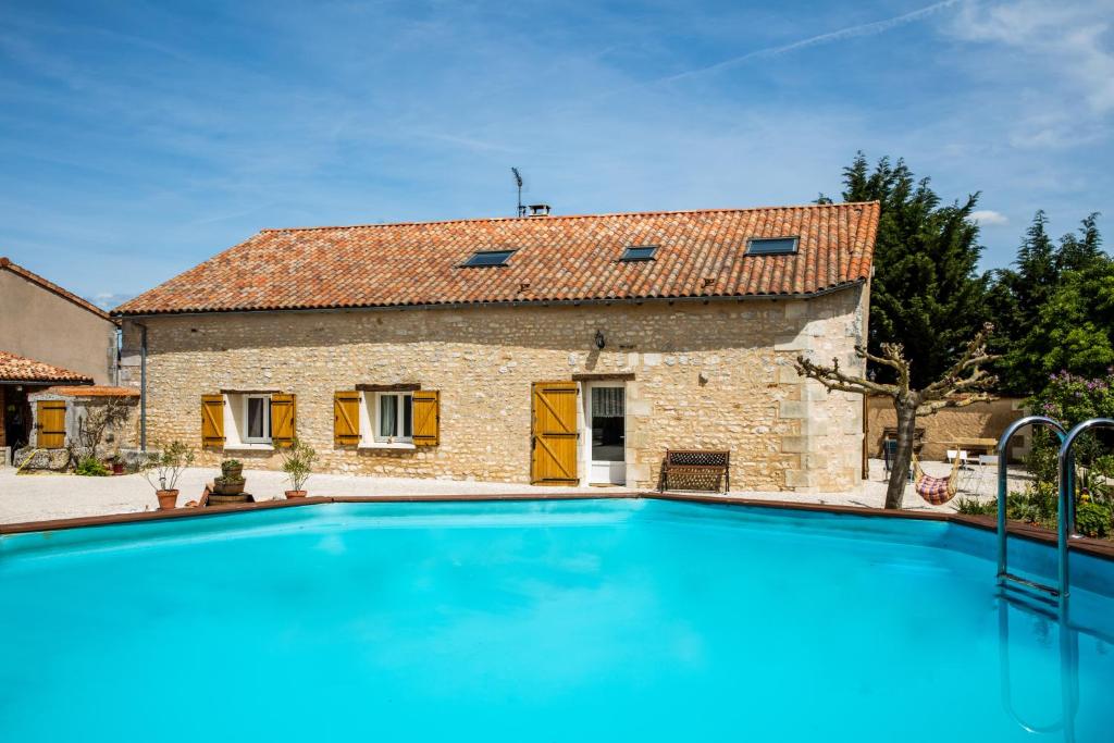 a large swimming pool in front of a stone house at The Wild Seeds in Chauvigny