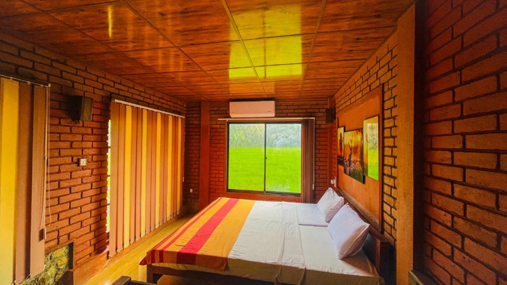 a room with a large window in a brick wall at Yala Savanna Leopard Lodge in Hambantota