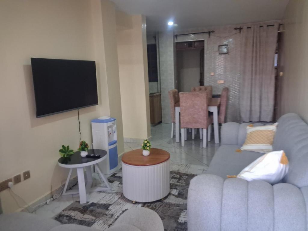 a living room with a couch and a flat screen tv at Texas Apartments 1 Bedroom bnb Thika in Thika