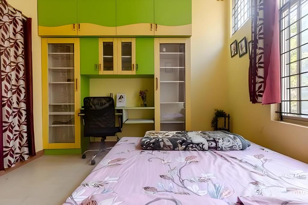 a bedroom with a bed and a chair in it at Forest View Penthouse Stay - PRIME HSR - Near NIFT in Bangalore
