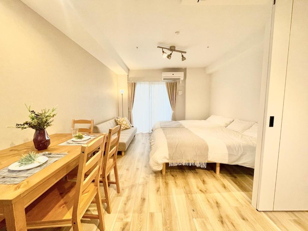 a bedroom with a bed and a table and a bed and a dining room at TIC HOTEL Hisayaodorisakae in Nagoya