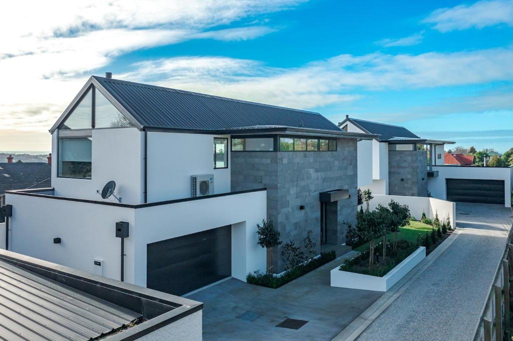 a white house with a black roof at Perfection on Park Lane in Timaru