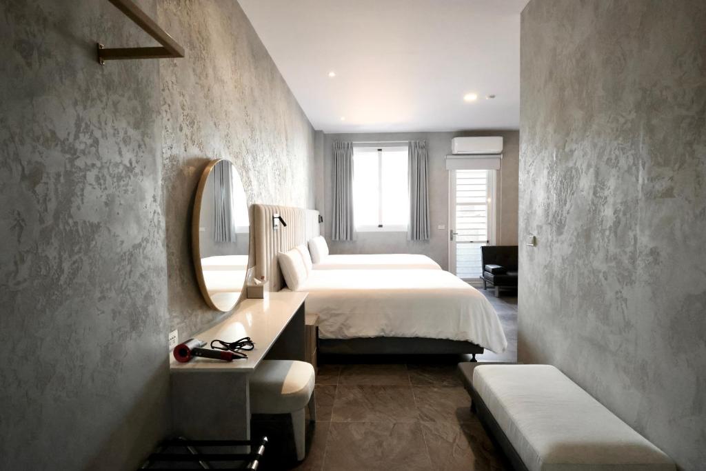 a bedroom with a large bed and a mirror at 芙蘿拉萃旅 in Taitung City
