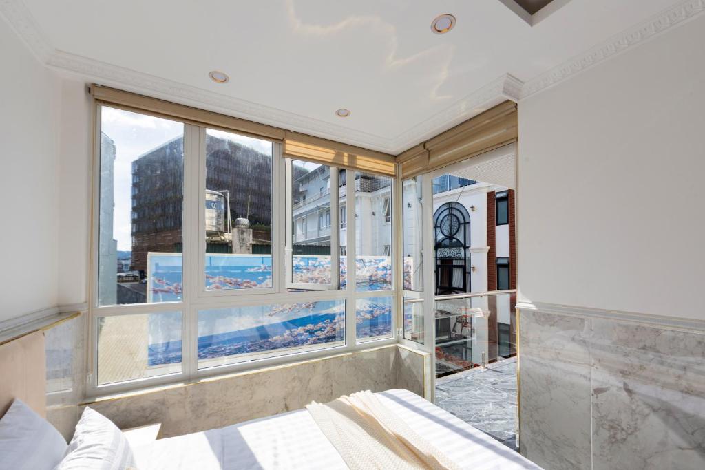 a bedroom with a large window with a view of a pool at Nghia Lan Hotel - Dalat Market in Da Lat