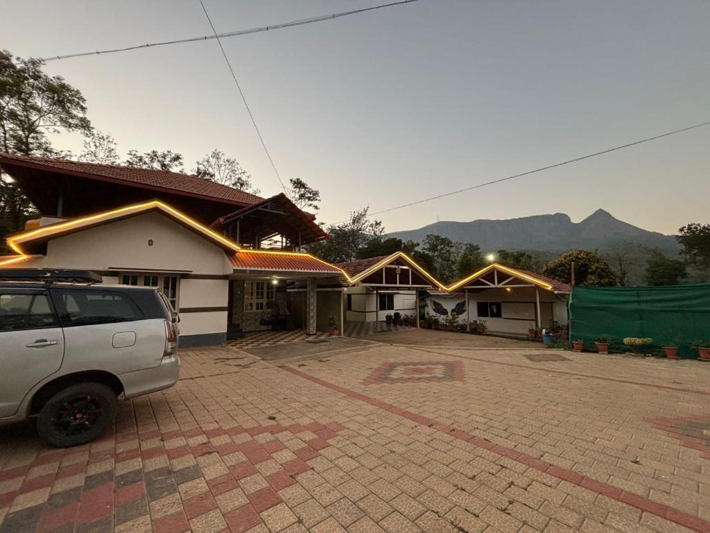 a row of houses with a car parked in a parking lot at New Hambala Homestay in Attigundi