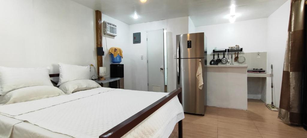 a bedroom with a bed and a kitchen with a refrigerator at John and Novy's beach bungalows in San Francisco