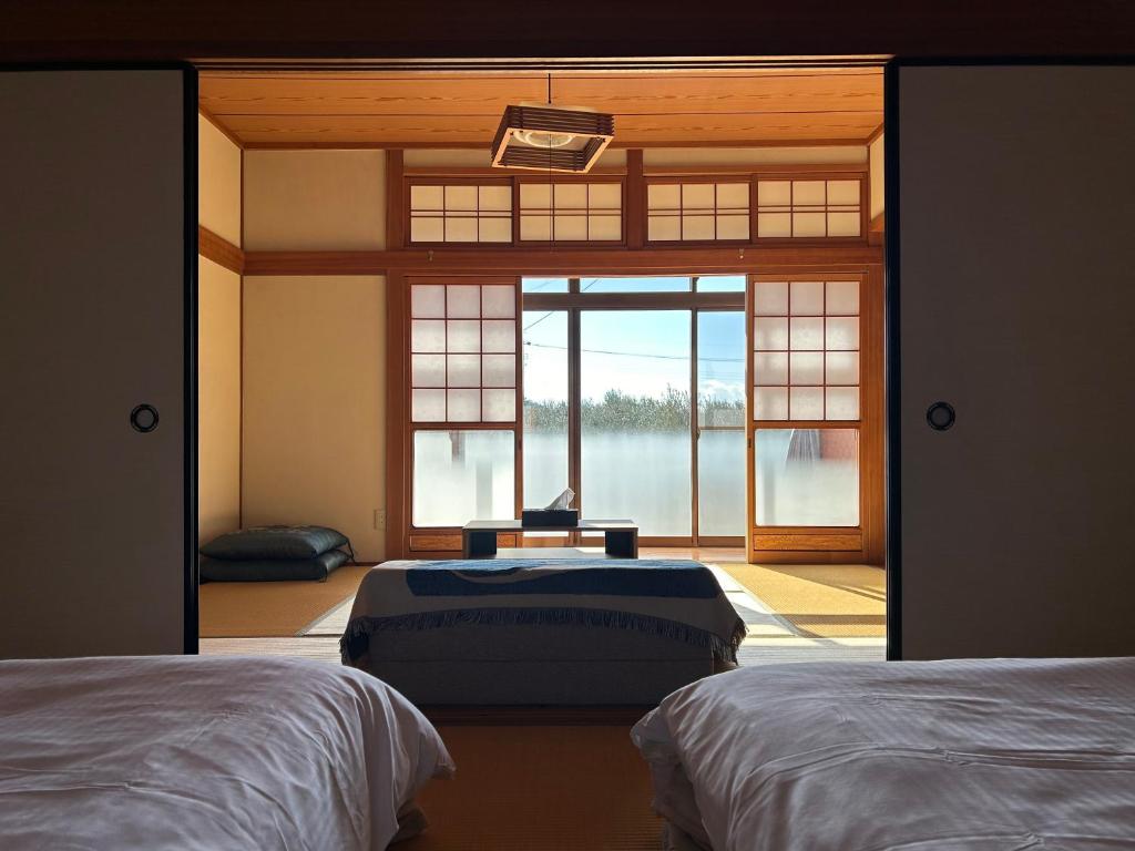 a room with two beds and a large window at Kia Ora Setouchi in Shodoshima
