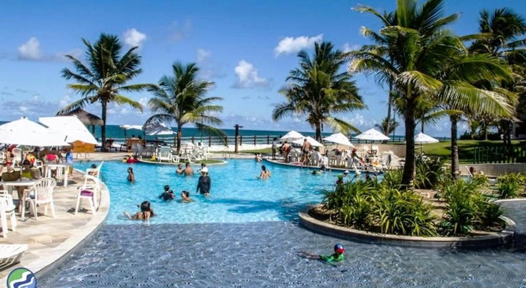 a group of people in a swimming pool at a resort at Flat no Beach Class Resort in Porto De Galinhas