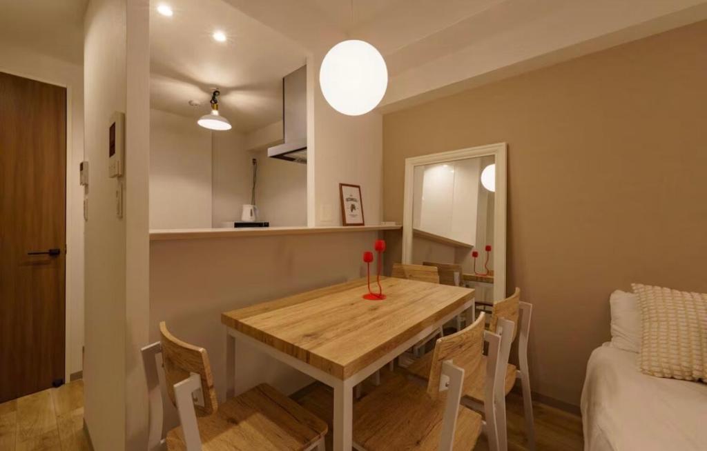a kitchen and dining room with a wooden table and chairs at TIC HOTEL NAGOYA Station in Nagoya