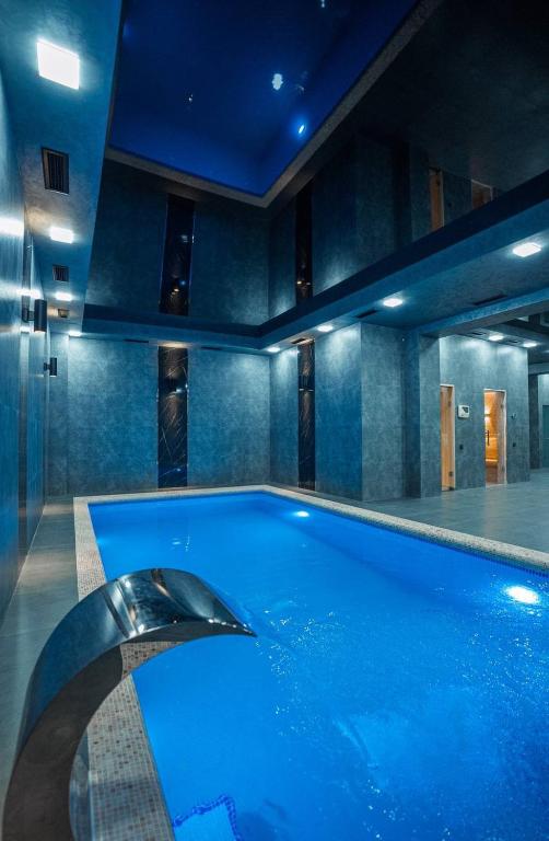 a swimming pool in a room with blue lighting at The Wood Hotel & Spa near Magic City in Tashkent