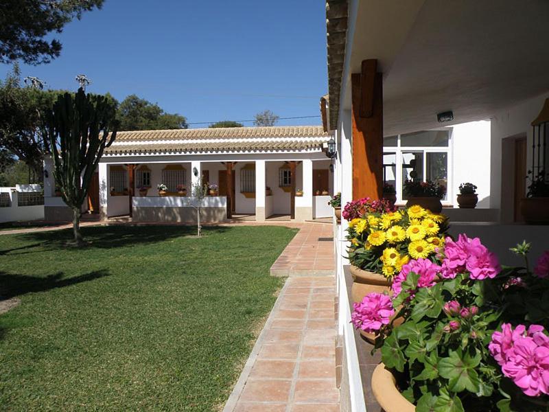 a house with flowers on the side of it at Hostal Las Acacias in Los Caños de Meca