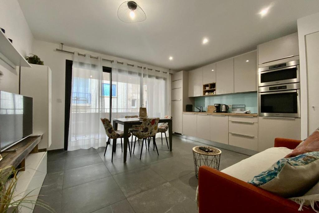 a kitchen and living room with a table and chairs at Villa Marie 2 Appartement tout confort climatisé 1 chambre proche plage in Le Grau-du-Roi