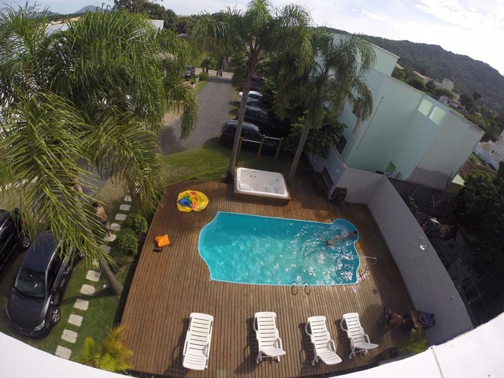 an overhead view of a swimming pool with chairs and palm trees at Pousada das Estrelas in Florianópolis